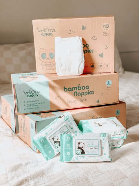 Cuddlies subscription bundle of nappies and water wipes on the bed