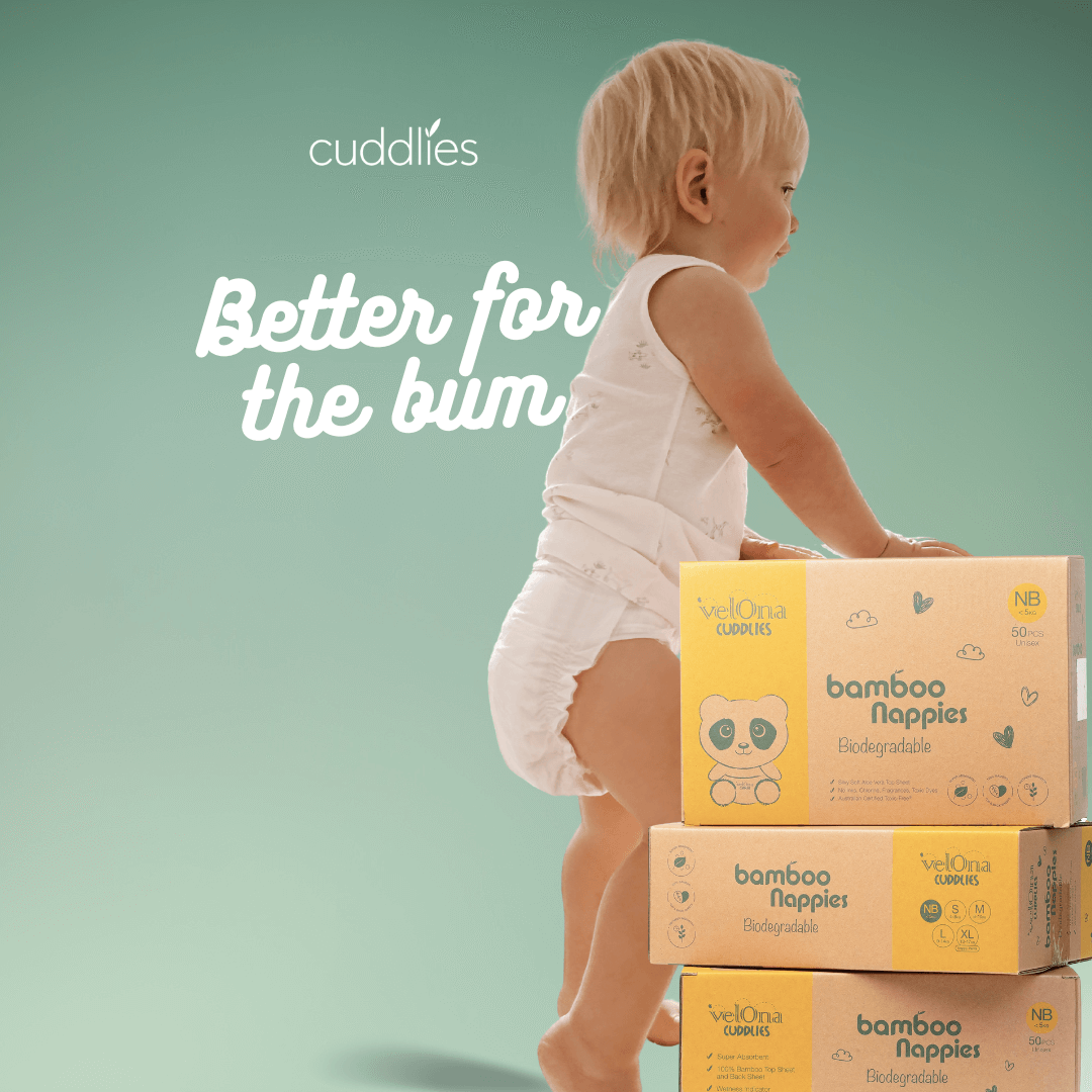 Smiling baby next to Cuddlies bamboo eco nappy boxes – safe, gentle, and eco-friendly nappies for sensitive skin