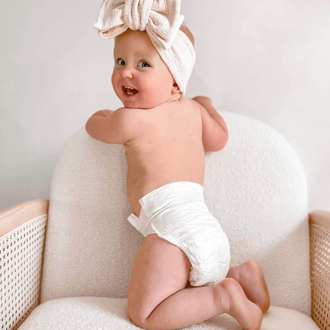 Smiling baby wearing Cuddlies bamboo eco nappy – soft, comfy, and gentle on sensitive skin
