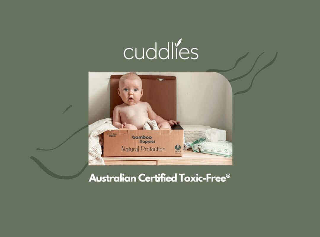 Baby sitting inside a Cuddlies recyclable nappy box - playful moments with eco-friendly nappies parents trust