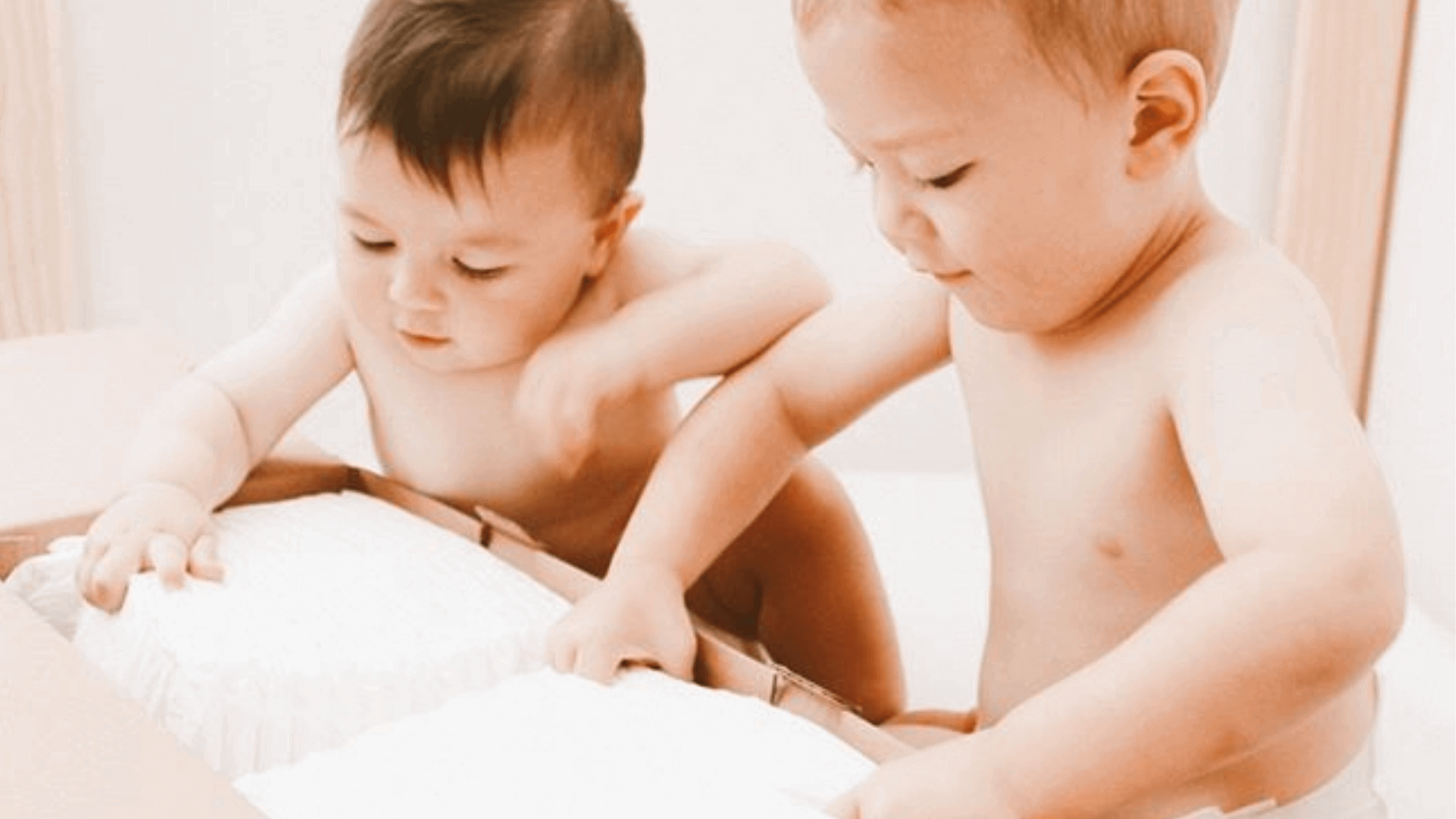 Two babies opening a Cuddlies nappy box – exploring eco-friendly nappies made for curious little ones