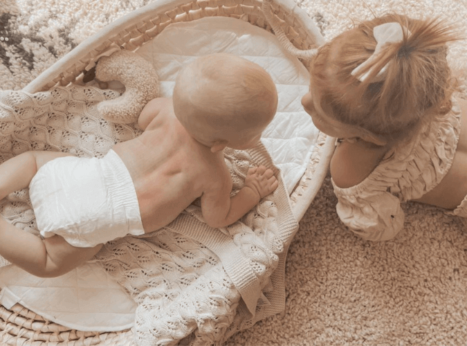 Baby on tummy time wearing a Cuddlies eco nappy – soft, breathable and gentle for delicate skin