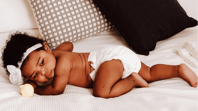 baby lying on side in a cuddlies eco nappy