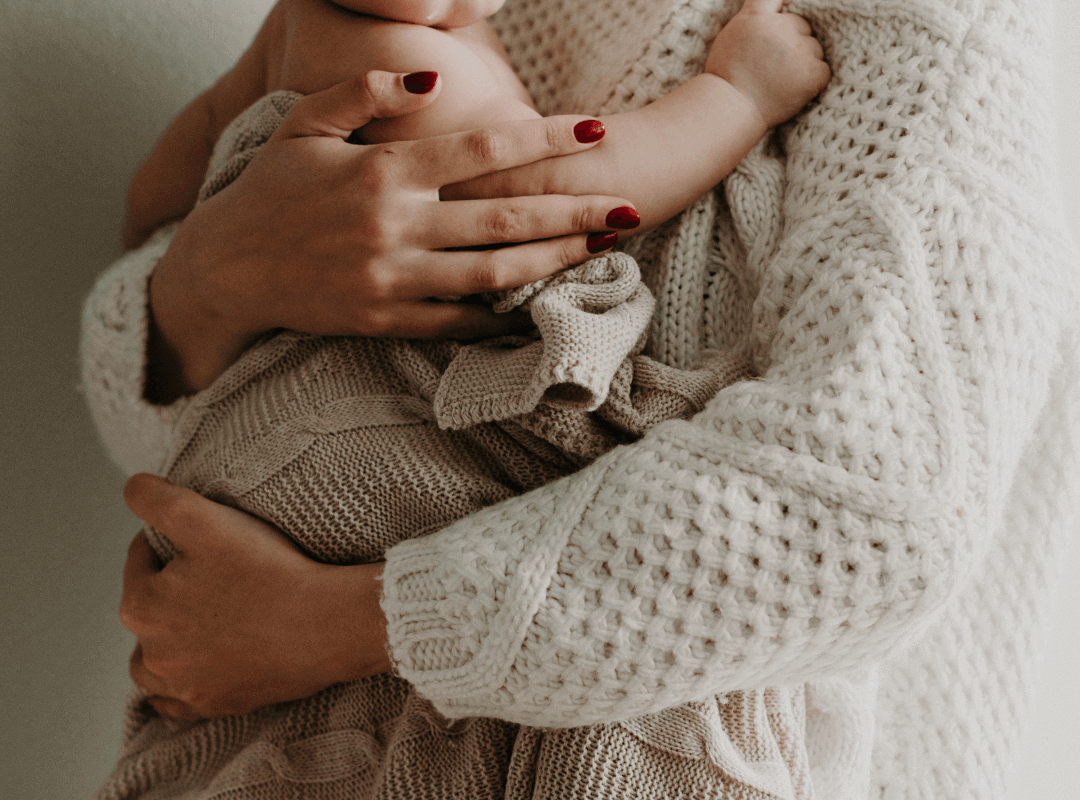 Mother holding baby in cuddlies eco nappy